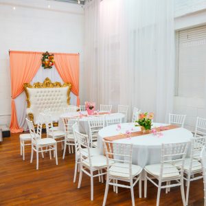 A stunning baby shower throne setup with peach draping and white-gold royal seating at Ridgewood Hall, Queens. Ideal for capturing royal moments during baby celebrations.