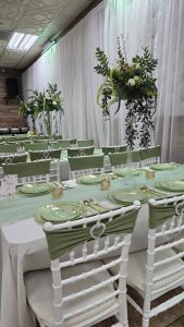 Elegant green-themed table setup at Occasions Hall. Perfect for baby showers, birthdays, and intimate events. Beautiful centerpieces and stylish seating for your celebration.