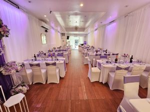 A comprehensive look at the event hall fully decorated in a white and purple theme. The cohesive design blends elegance and functionality, making it suitable for both formal and casual gatherings.