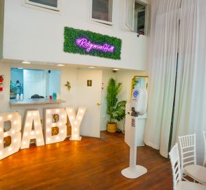 Make an unforgettable entrance! This baby shower setup at Ridgewood Hall features glowing BABY letters, a #RidgewoodHall neon sign, and modern decor in a cozy Queens venue.