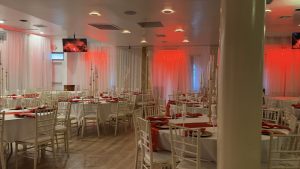 Atlantis Hall’s warm red lighting and modern white seating create the perfect party atmosphere — ideal for birthdays, weddings, and private celebrations in Queens NY.