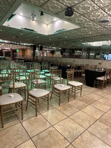 A professional seating arrangement with gold chiavari chairs and mirrored walls, suited for weddings, seminars, award ceremonies, and private functions.