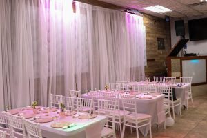 Occasions Hall provides pristine, coordinated table settings and plush white chairs—ideal for seated meals at baby showers, birthdays, or family functions.