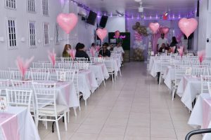 Full view of Abyss Hall event space decorated with pink heart balloons, white chiavari chairs, and ambient purple lighting – perfect venue for baby showers and family events in NYC.