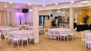 Open concept layout at Twilight Hall featuring Chiavari chairs, floral centerpieces, and cozy event ambiance – affordable party hall in Queens.