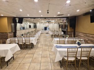 A stylish blue and gold event theme at Medina Hall featuring modern table decor and a beautiful balloon backdrop. Ideal for showers, birthdays, and more.